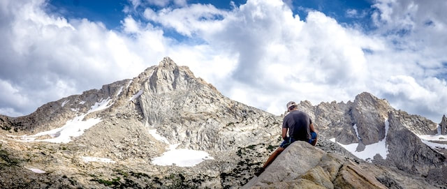a man standing on a rock observing a mountaintop